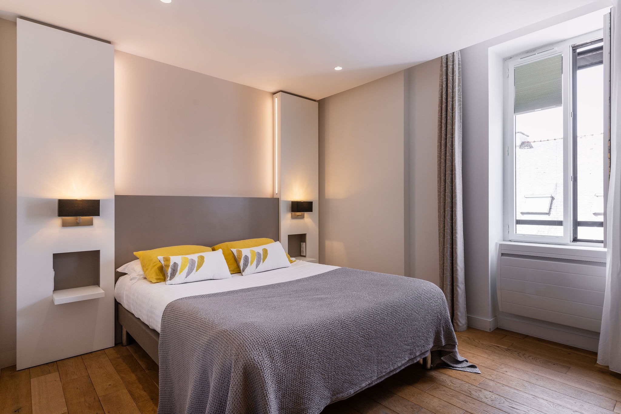 Chambre standard avec lit double, décor moderne, tons neutres et accents jaunes dans un hôtel à Bénodet.