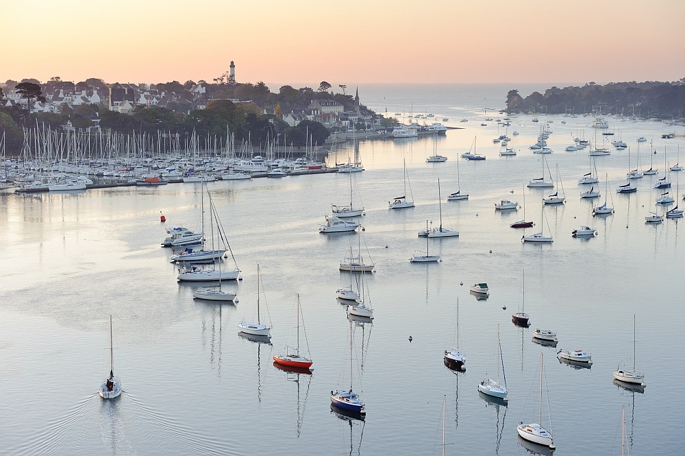 Vue panoramique sur la rivière de l’Odet et le port de Bénodet, avec de nombreux voiliers au mouillage et le phare de la Pyramide en arrière-plan. Photo BERTHIER Emmanuel.